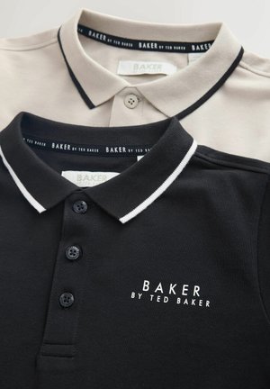 Kaksi poolopaitaa, yksi musta valkoisilla yksityiskohdilla ja logolla, toinen beige mustilla yksityiskohdilla. Molemmissa on nappilista ja klassinen kaulus.