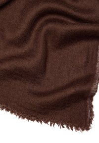 Brązowy, lekki szalik o miękkiej, teksturowanej powierzchni i postrzępionych brzegach. Materiał wydaje się puszysty i efektownie układa się w luźnych fałdach.