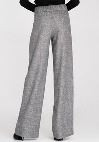 Szare spodnie w stylu wide-leg z teksturowanej tkaniny, elastycznym paskiem w talii i luźnym krojem, z subtelnym wzorem dla dodatkowego akcentu.