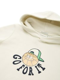 Felpa in cotone organico crema con grafica frontale di un personaggio di basket sorridente che indossa un cappellino verde, con la scritta "FALLA PER BENE."
