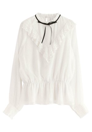 Blusa blanca de manga larga con detalle de encaje en forma de V con volantes, cintura ceñida, puños fruncidos y lazo delgado negro en el escote.