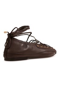 Chaussures plates en cuir marron avec un design à lacets et œillets dorés, semelle plate et texture lisse. Rubans noués à l'arrière.