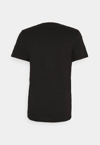 Camiseta negra de cuello redondo hecha de algodón suave. Mangas cortas y un diseño simple y sin adornos. Sin gráficos ni patrones visibles.