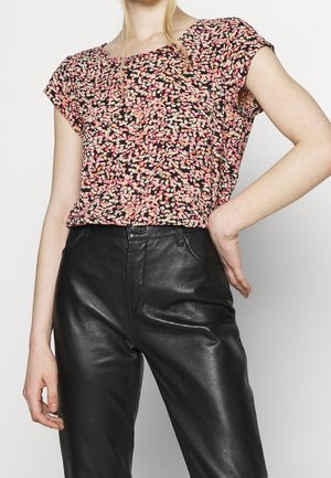 Blomstermønstrede bluse i sort, pink og creme; korte ærmer, afslappet pasform, letvægtsstof. Kombineret med høj talje læderbukser.