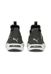 Chaussures de sport noires avec une tige texturée, dotées d'une semelle extérieure blanche, d'accents de marque et de languettes à l'arrière pour un enfilage facile.