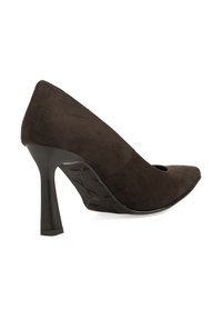 Zapato de tacón alto de ante negro con punta afilada y parte trasera curva. Presenta una suela de goma negra texturizada y un tacón delgado.