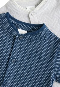 Zwei Babykardigans: einer in Marineblau mit geometrischem Muster und Knopfverschluss, der andere in Hellgrau mit strukturiertem Design und kontrastierendem Kragen.