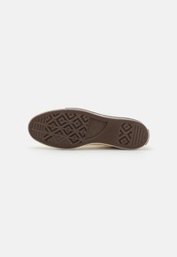 Sola de sapato de borracha em castanho com padrões de piso geométricos. Apresenta uma borda superior de cor clara, textura suave e contorno do salto bem definido.