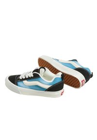 Sneaker in tela con un design in gradiente nero e blu, dettagli bianchi e suola in gomma con motivo a cialda.