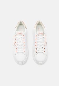 White sneakers with a smooth texture, featuring orange eyelets and accents. Logo on tongue and side. Low-top design. Flat rubber sole.