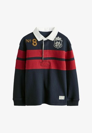 Tmavomodrá ragbyová košeľa s dlhými rukávmi, červenými pruhmi, bielym golierom, zlatým číslom „No 8“ na hrudi a bielym vyšitým erbom na ľavej hornej strane.