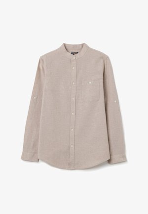 Camisa de color beige claro, de manga larga y fabricada en lino. Presenta un cuello de banda, puños con botón y un bolsillo en el pecho.