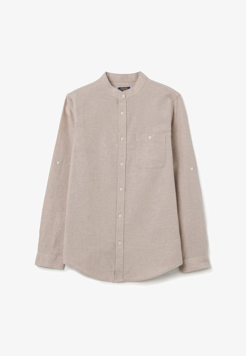 Camisa de color beige claro, de manga larga y fabricada en lino. Presenta un cuello de banda, puños con botón y un bolsillo en el pecho.