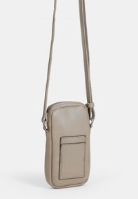 Beige lädercrossbodyväska med en slät textur, rektangulär form, dragkedjestängning och en framficka. Har ett tunt justerbart rem.