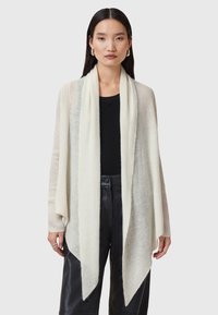 Ljust beige stickad cardigan med öppen front, lång ärm och draperad nederkant. Texturerat material med subtila ränder och mjuk yta.