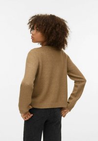 Rjava pletena pulover z okroglim izrezom in dolgimi rokavi. Ima preprost rebrasti rob, teksturirano tkanino in sproščen kroj.