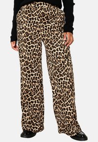 Leopard print wide-leg pants in tan and black fabric, featuring an elastic waistband. Paired with a black sweater and shiny black shoes.