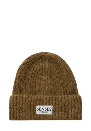 Ribbed brown beanie hat with a turned-up cuff and a white fabric label featuring black text. Made from textured knit material.