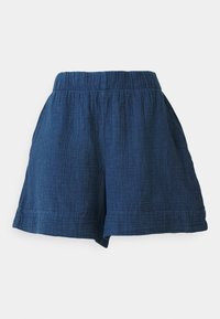 Mėlynos pintos šortai su elastinga juosmens juosta, laisvo kirpimo ir tekstūrinio audinio. Apačios yra tvarkingai siūtos, suteikiančios neformalų įvaizdį.