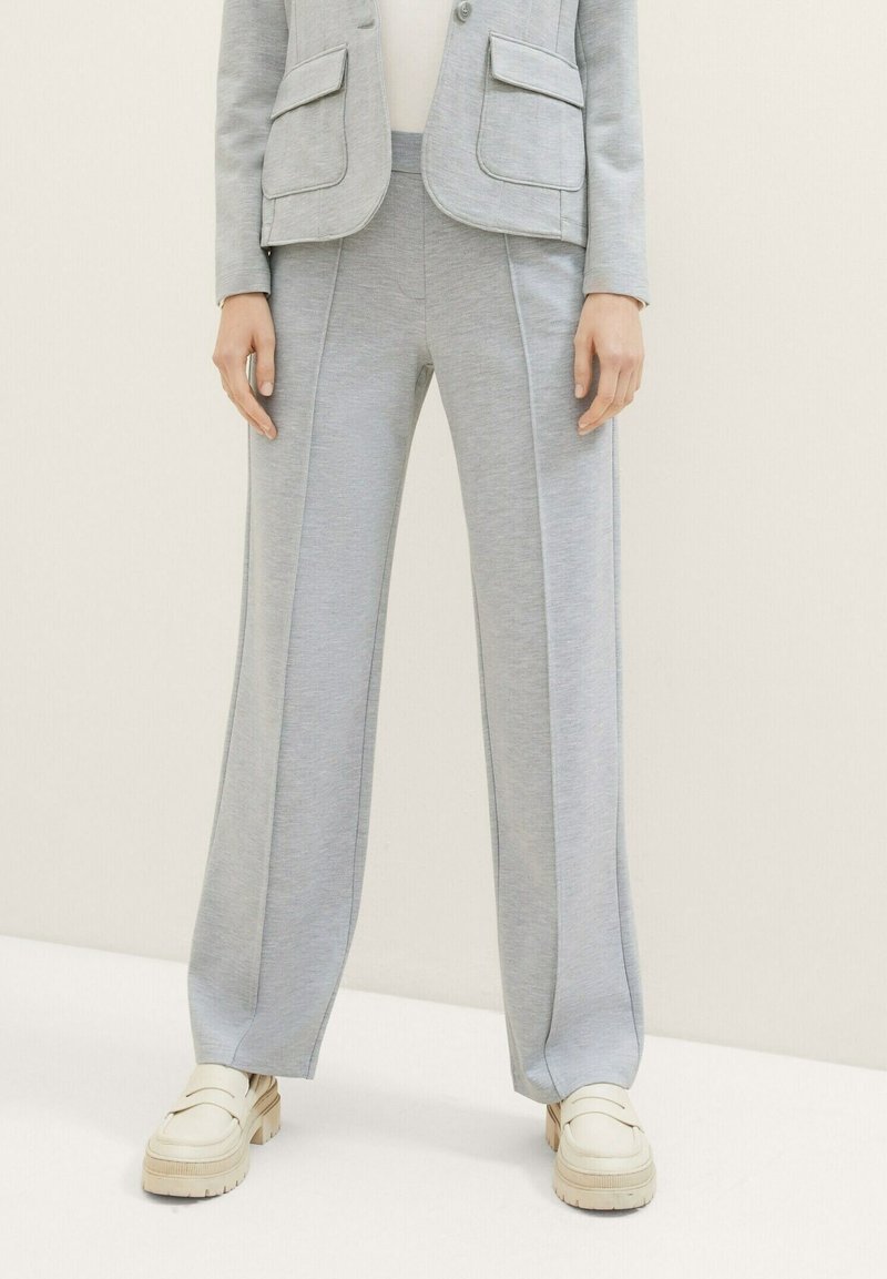 Lichtgrijze brede sweatpants van een textuurstof, met zijnaad en een comfortabele tailleband, gecombineerd met beige platform loafers.