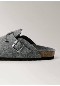 Pantofole grigie in feltro con fibbia regolabile in argento, design aperto davanti, soletta in sughero e suola in gomma nera testurizzata.