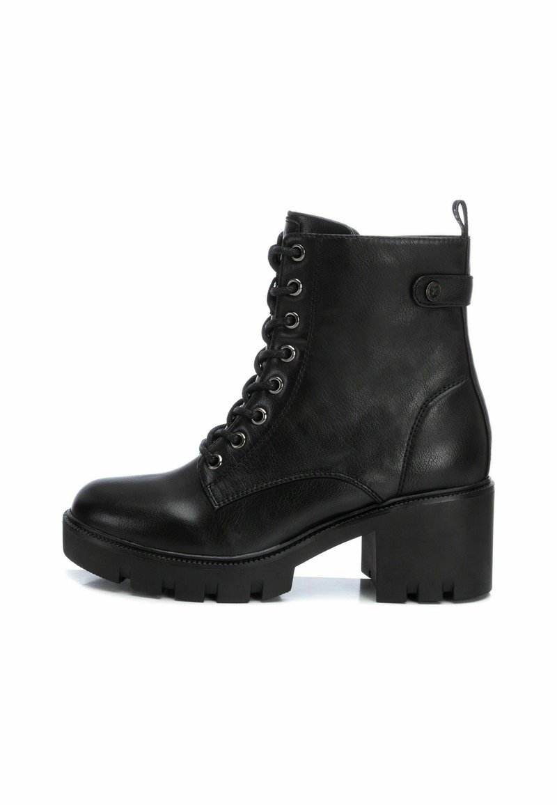 Schwarze Schnürstiefeletten aus strukturiertem Leder, mit einem kräftigen Absatz, runder Zehenpartie und metallischen Ösen. Kurze Zuglasche an der Rückseite.
