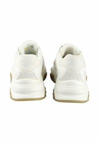 White sneakers with a smooth leather upper, textured accents, cushioned sole, and embossed logo on the heel. Rubber outsole in beige.
