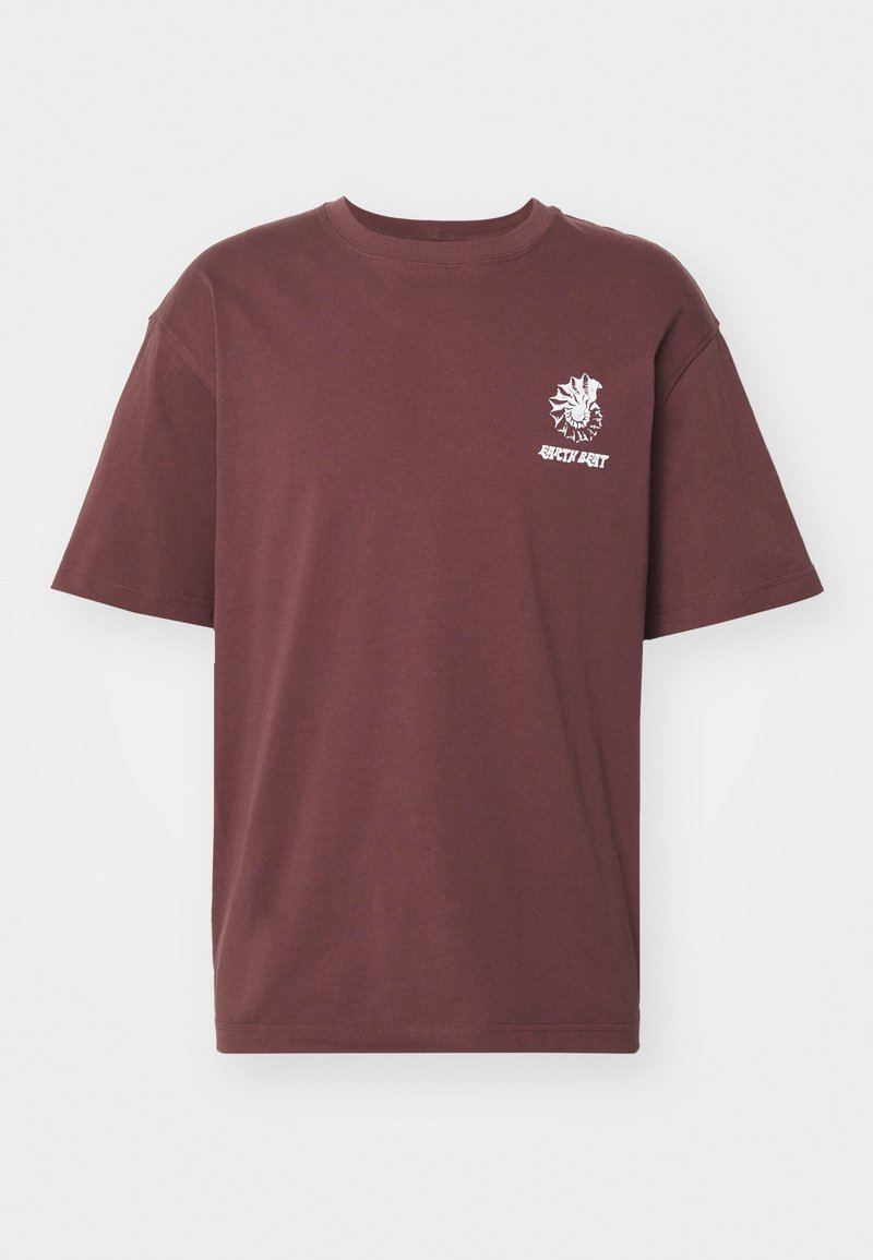 T-shirt à manches courtes couleur marron avec un petit graphique blanc représentant un soleil et un visage, ainsi qu'un texte, situé sur la partie gauche de la poitrine.