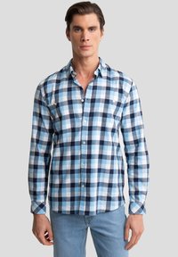 Heren geruit overhemd in lichtblauw en marineblauw met een button-down kraag, lange mouwen en twee borstzakken. Gemaakt van een gestructureerde katoenmix.