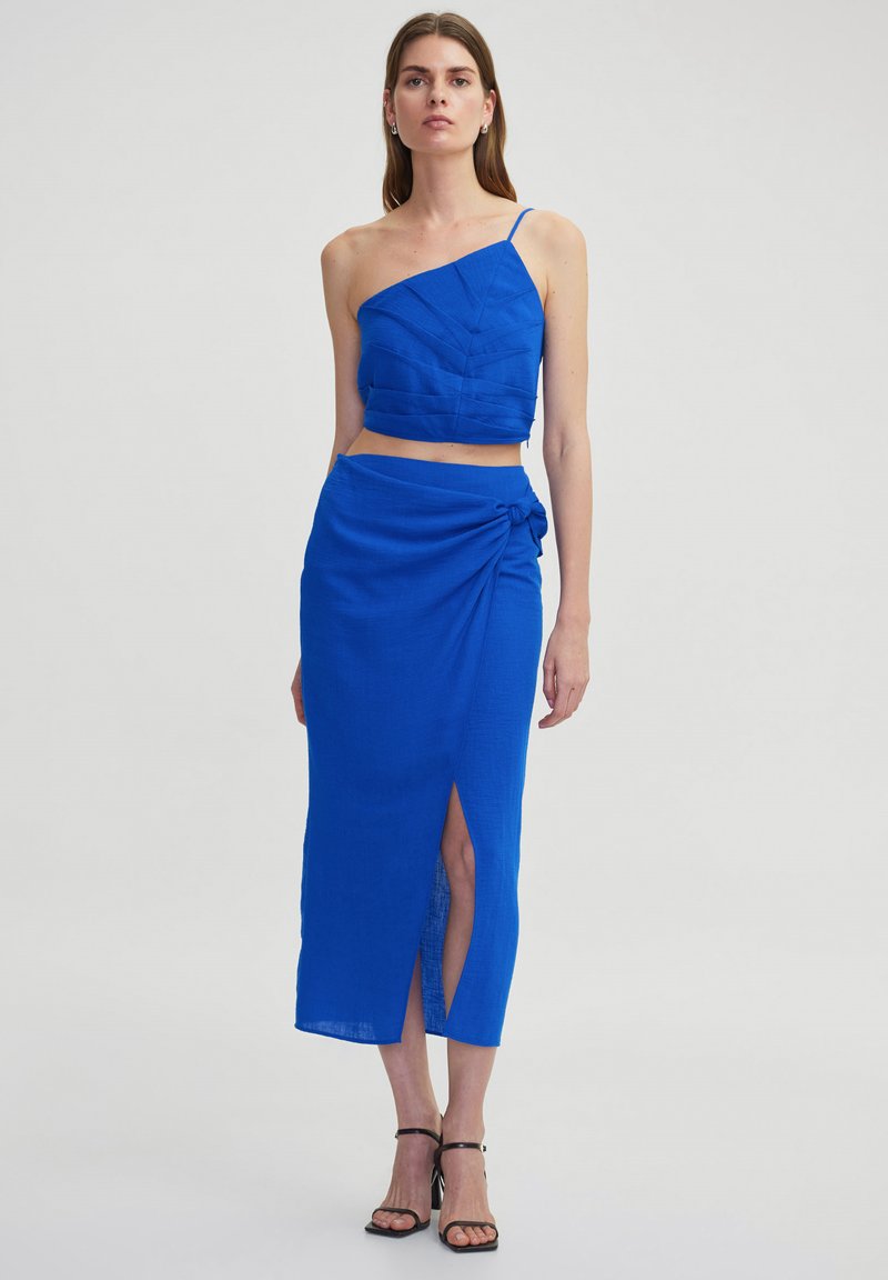 Blauw, textuurvol tweedelig outfit met een aansluitende, asymmetrische crop top en een wikkelrok met een zijsplits en knoopdetail.