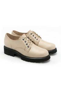 Beige lædersko med en glat tekstur, rund tå, sort gummisål og metaløjer til snørebånd. Klassisk oxford-design.