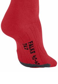 Calzino rosso realizzato in tessuto testurizzato, con un logo nero e indicazioni di misura sul lato. La punta è arrotondata con un accento grigio.