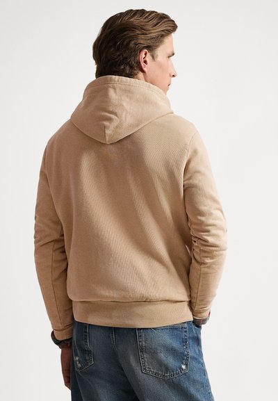 Sweatshirt bege com capuz, tecido texturizado, bainha e punhos canelados. Confeccionada com corte descontraído, costuras visíveis e capuz grande.