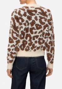 Maglione crema morbido con stampa leopardata marrone, scollo rotondo e maniche lunghe. Orlo e polsini a coste; materiale morbido e testurizzato.