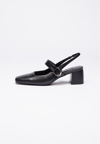 Sort læderslingback-sko med firkantet tå, justerbar rem og geometrisk blokhælv. Glat tekstur og minimalistisk design.