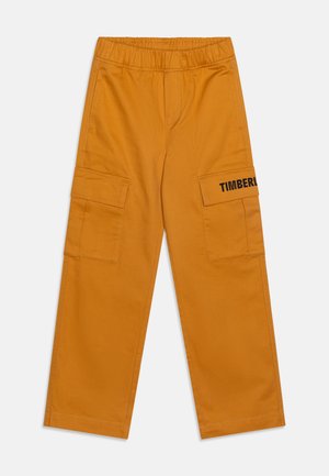 Sennepsgule cargobukser med elastisk talje, klaplommer på siderne og delvist "Timberland" logo på den højre lommeklap.
