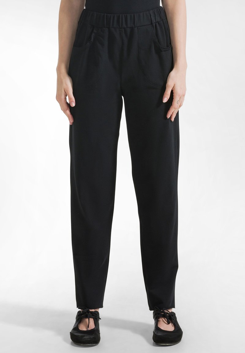 Pantaloni cu talie elastică neagră și buzunare laterale. Prezintă o textură netedă și un design cu picior conic, potriviți pentru purtare casual.