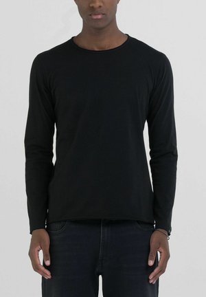 T-shirt nera a maniche lunghe in materiale cotone, con scollatura rotonda e vestibilità comoda. Senza pattern o dettagli visibili.