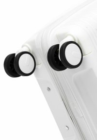 White hard-shell suitcase with a textured surface and smooth zipper, featuring black rubber wheels with white rims for easy maneuverability.