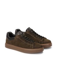 Zapatillas de ante marrón oscuro con detalles en cuero negro, punta redonda y cordones negros. Suela gruesa de goma con agarre texturizado. Diseño casual.