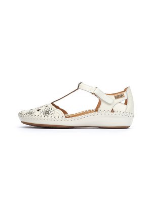 White leather sandal with perforated design and T-strap. Features stitched detailing along the sole and a buckled closure. Flat sole.