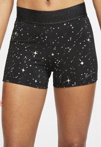 Pantalones cortos deportivos negros con un estampado de estrellas brillantes, que cuentan con una cinturilla elástica negra grabada con "NIKE PRO" para mayor estilo y soporte.