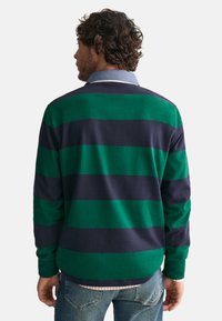 Langsleeve shirt met groene en marineblauwe horizontale strepen, een denim kraag, zachte stof en een relaxte pasvorm. Achteraanzicht toont de vorm van het shirt.
