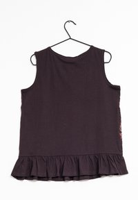 Tmavě fialový top bez rukávů s volánkovým lemem, vyrobený z bavlněné látky, s texturovaným bočním vzorem. Zavěšený na černém háčku.
