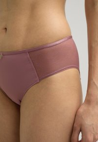 Rosa Bikini-Unterteil mit glatter Textur, transparenten Netz-Akzenten und einem gemusterten Einsatz an der Seite. Einfache elastische Taille.
