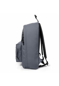 Zaino grigio con una forma strutturata, tasca frontale con zip, spallacci regolabili e dettagli neri a contrasto sul retro e sul fondo.