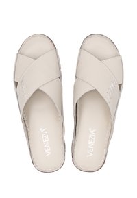 Beige šlapky s křížovými popruhy vyrobené z hladkého syntetického materiálu, s dekorativním šitím a otevřenou špičkou.