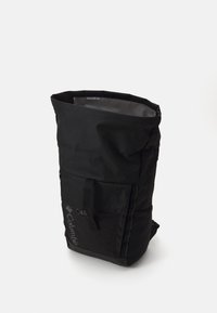 Black roll-top backpack with a textured exterior, adjustable straps, side zip pocket, and embossed logo on the front. Waterproof material.