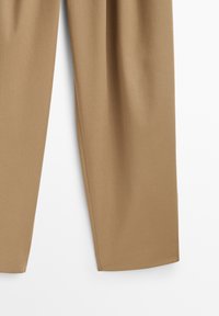 Bruna, skräddarsydda byxor i ett mjukt, texturerat tyg. Har en rak ben-design med subtila sömnadsdetaljer. Inga fickor synliga.