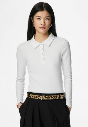 Wit poloshirt met lange mouwen, geribbelde textuur en kraag, voorzien van een knoopsluiting en gecombineerd met een zwarte broek en een riem met luipaardprint.